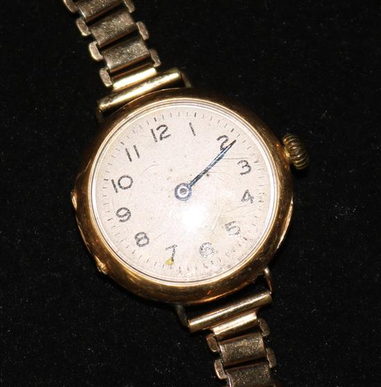 A ladys 18ct gold manual wind wrist watch on a gilt metal bracelet.